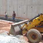 Retaining wall side drain construction with masonry work